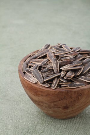 Photo for Sunflower seeds in a bowl on a wooden background - Royalty Free Image