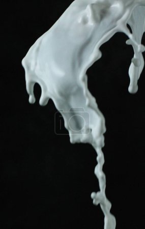Téléchargez les photos : Éclaboussure de liquide blanc sur fond noir - en image libre de droit
