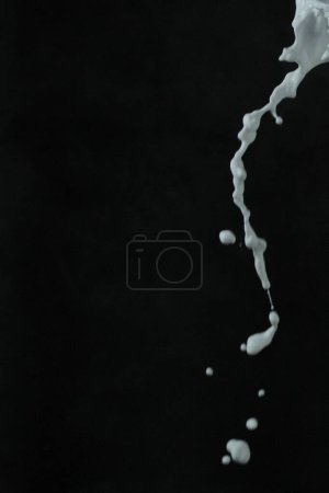 Téléchargez les photos : Éclaboussure blanche avec des gouttes noires - en image libre de droit