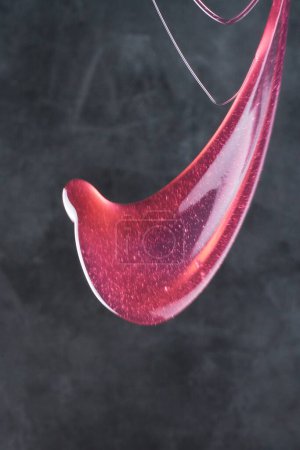 Téléchargez les photos : Vin rouge coulant sur un fond sombre - en image libre de droit