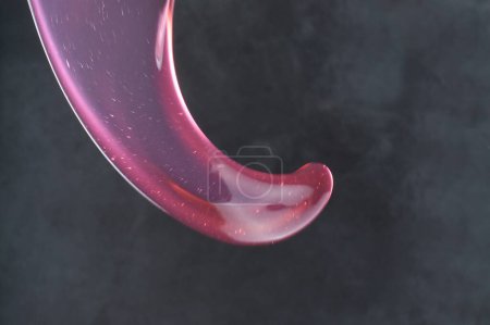 Foto de Salpicadura de líquido en forma de líquido rojo con una gota de agua. concepto abstracto de cosmética y textura. 3 d ilustración - Imagen libre de derechos