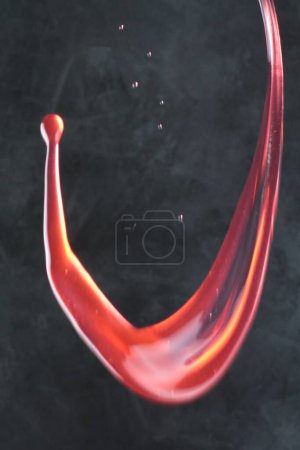 Téléchargez les photos : Éclaboussure de vin rouge sur fond noir. - en image libre de droit