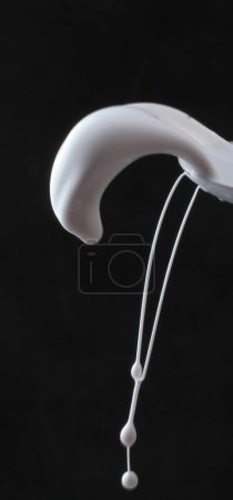 Photo for White cream with a splash of milk on a black background. - Royalty Free Image