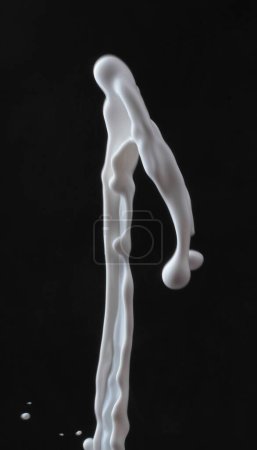 Téléchargez les photos : Éclaboussures de lait sous forme de liquide noir sur fond blanc - en image libre de droit