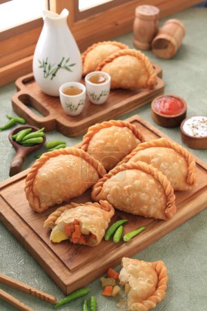 Photo for Jalangkote  is a South Sulawesi fried dumpling from Indonesian cuisine, stuffed with rice vermicelli, vegetables, potatoes and eggs. Spicy, sweet and sour sauce will be dipped into prior to be eaten. - Royalty Free Image