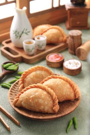 Photo for Jalangkote  is a South Sulawesi fried dumpling from Indonesian cuisine, stuffed with rice vermicelli, vegetables, potatoes and eggs. Spicy, sweet and sour sauce will be dipped into prior to be eaten. - Royalty Free Image