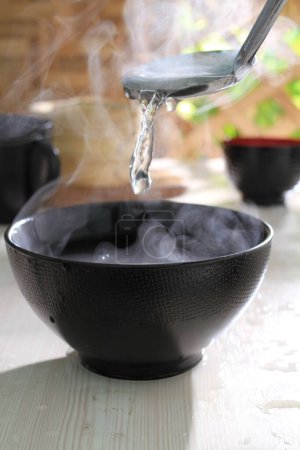 Photo for A closeup of black and white kettle on the table in the background of the blurred smoke - Royalty Free Image