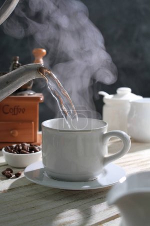 Foto de Granos de café y una taza de café en una mesa de madera - Imagen libre de derechos