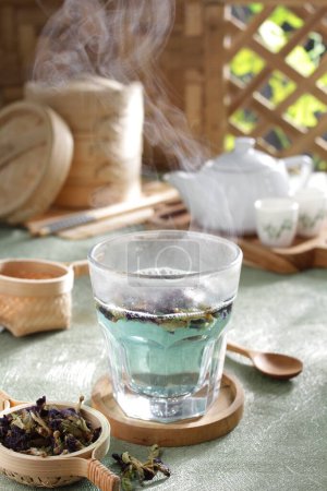 Téléchargez les photos : Thé vert dans une tasse en verre sur une table en bois - en image libre de droit