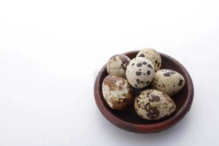 Foto de Huevos de codorniz en un plato de barro sobre un fondo blanco. foto de alta calidad - Imagen libre de derechos
