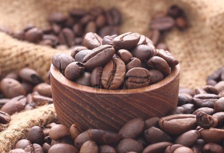 Photo for Coffee beans in a cup on wooden surface with blurred background - Royalty Free Image