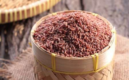 red rice in a wooden bowl on a wooden background