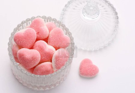 Téléchargez les photos : Bonbons en forme de coeur dans un bol en verre sur fond blanc, vue de dessus - en image libre de droit