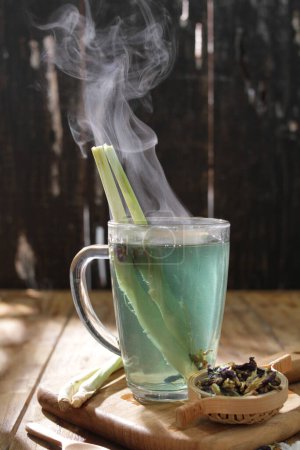 Foto de Té verde con leche y limón sobre un fondo de madera - Imagen libre de derechos