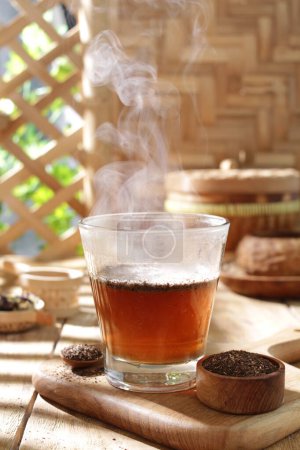 Foto de Taza de té caliente con canela y anís sobre tabla de madera - Imagen libre de derechos