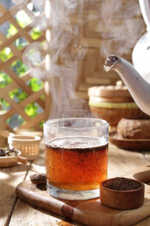 Téléchargez les photos : Verre de thé chaud avec glace sur une table en bois - en image libre de droit