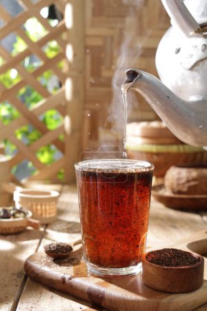 Téléchargez les photos : Thé chaud dans une tasse sur une table - en image libre de droit