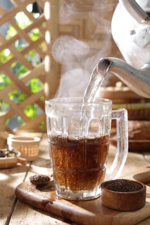 Téléchargez les photos : Tasse de café chaud sur une table en bois dans la nature - en image libre de droit