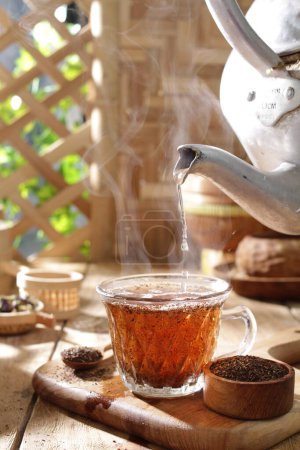 Téléchargez les photos : Tasse de thé avec théière sur une table en bois - en image libre de droit
