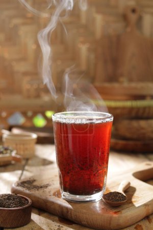 Foto de Té con limón en un vaso sobre fondo de madera - Imagen libre de derechos