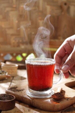 Foto de Taza de té con canela y azúcar en la mesa de madera - Imagen libre de derechos