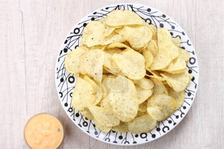 Photo for Chips and sauce with a plate on a gray background, close - up - Royalty Free Image
