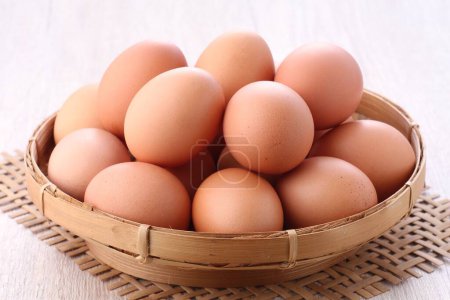 Photo for Eggs in the wooden basket on the white background - Royalty Free Image