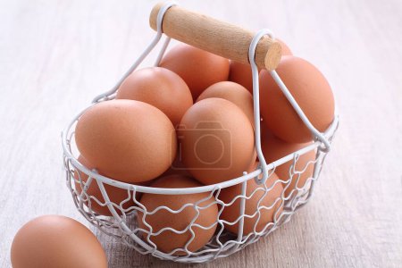 Téléchargez les photos : Panier avec œufs sur fond bois blanc - en image libre de droit
