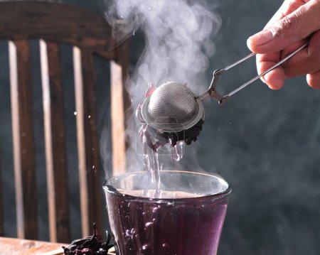 Photo for A closeup of pouring tea in a kettle with a spoon - Royalty Free Image