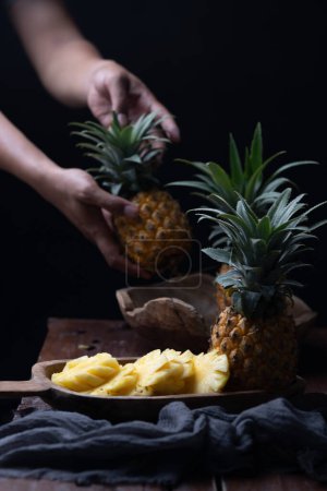Photo for Woman hand hold fresh pineapple in the background - Royalty Free Image