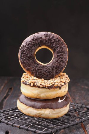 Photo for Delicious donut with chocolate glaze and sprinkles on wooden table - Royalty Free Image