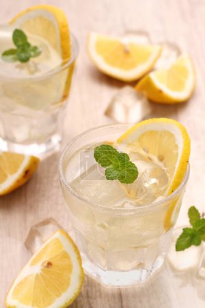 Foto de Refrescante limonada con menta y hielo sobre mesa blanca, primer plano - Imagen libre de derechos