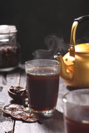 Téléchargez les photos : Thé chaud à la cannelle et une tasse de thé chaud sur une table noire. photo de haute qualité - en image libre de droit
