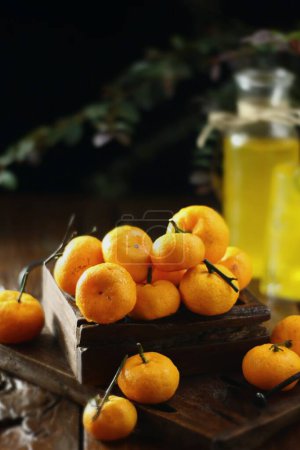 Téléchargez les photos : Mandarines fraîches mûres aux feuilles et fruits sur une table noire - en image libre de droit