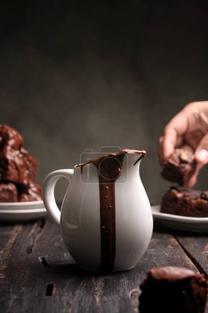 Photo for Pouring chocolate pieces with chocolate on table - Royalty Free Image
