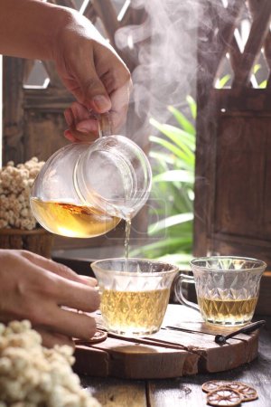 Téléchargez les photos : Gros plan d'un verre de thé dans une théière - en image libre de droit