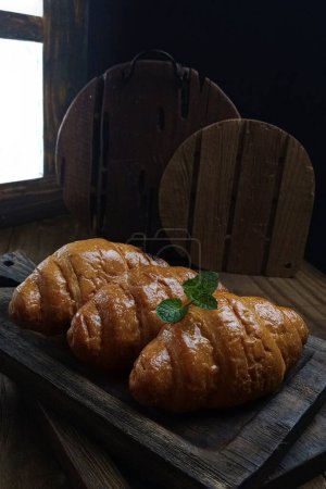 Photo for A closeup shot of a croissant with a cup of coffee in a cafe - Royalty Free Image