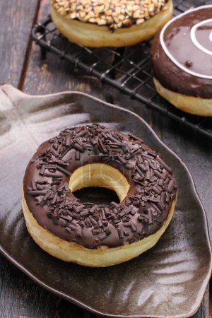 Photo for Chocolate donuts with icing and chocolate glaze on plate - Royalty Free Image