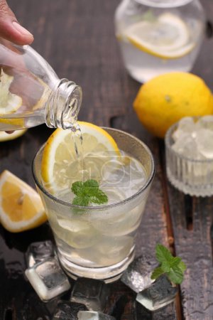 Foto de Vaso de limonada fría con limón y cubitos de hielo - Imagen libre de derechos
