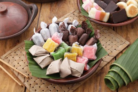 Téléchargez les photos : Dodol est une collation à base de farine de riz collante, de lait de coco et de cassonade, parfois mélangée avec des fruits, tels que le durian, le soursop enveloppé dans des feuilles (maïs), du papier, etc.. - en image libre de droit