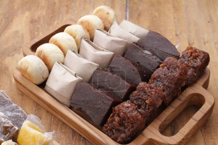 Photo for Dodol or jenang is a snack made from sticky rice flour, coconut milk, and brown sugar, sometimes mixed with fruit, such as durian, soursop wrapped in leaves (corn), paper, and so on. - Royalty Free Image