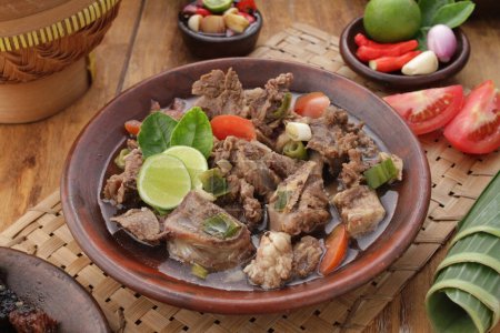 Téléchargez les photos : Satay de chèvre servi avec sauce aux arachides ou sauce soja aux échalotes tranchées, concombre et poivre de Cayenne - en image libre de droit