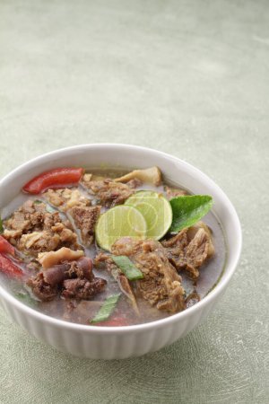 Photo for Indonesian food, goat soup served with lime juice, sliced tomatoes, sliced spring onions and hot chili sauce - Royalty Free Image
