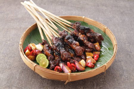 Photo for Goat satay served with peanut sauce or soy sauce with sliced shallots, cucumber and cayenne pepper - Royalty Free Image