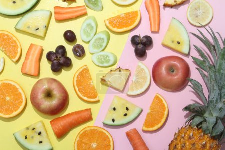 Foto de Composición laica plana de frutas y verduras sobre fondo rosa - Imagen libre de derechos