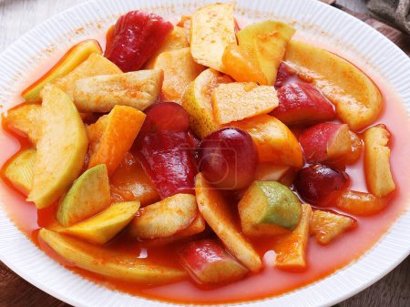 Foto de Alimentos indonesios, fruta fresca en escabeche con salsa hecha de jugo de limón, chiles y otras especias - Imagen libre de derechos