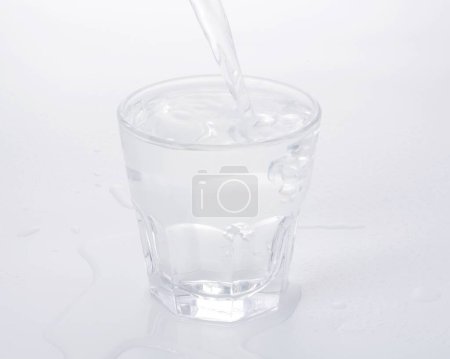 Foto de Vaso de agua con hielo y burbujas sobre fondo blanco - Imagen libre de derechos