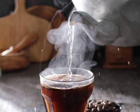 Foto de Té caliente en taza con hielo y granos de café en la superficie de madera - Imagen libre de derechos