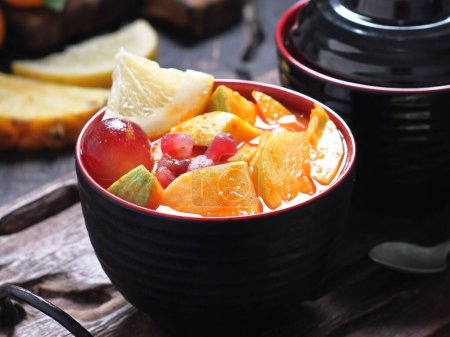 Photo for Fruit salad with fresh oranges and peaches in the bowl - Royalty Free Image