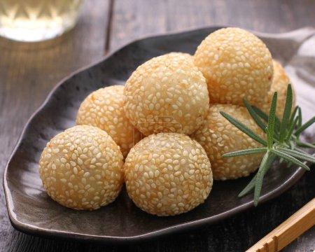 Photo for A plate of sesame balls with a sprig of rosemary - Royalty Free Image